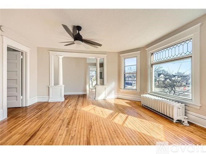 A room with wooden floors and a ceiling fan.