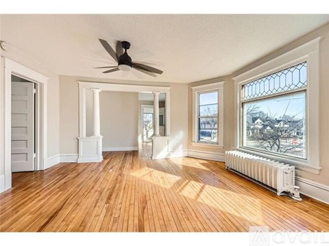 A room with wooden floors and a ceiling fan.