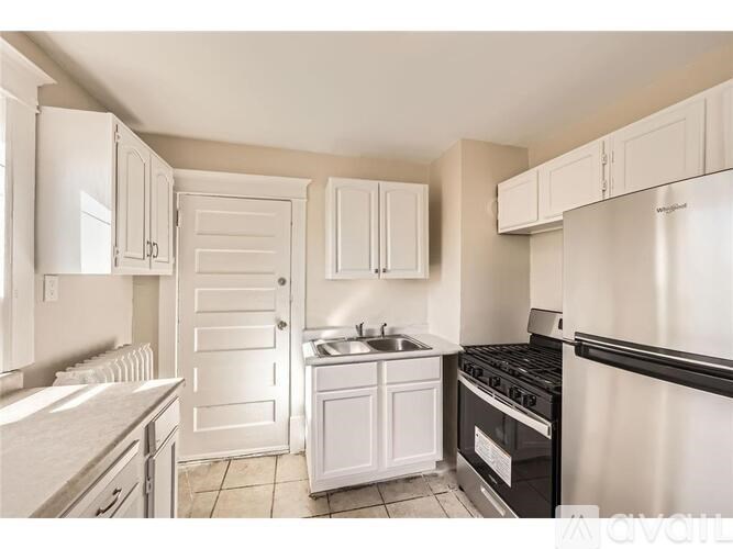 A kitchen with white cabinets and appliances.