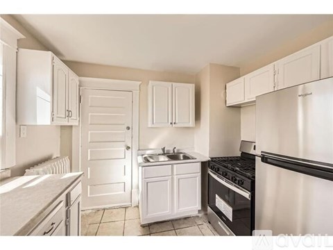 A kitchen with white cabinets and appliances.