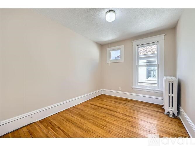 A room with wooden floors and a window with a white frame.