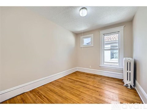 A room with wooden floors and a window with a white frame.