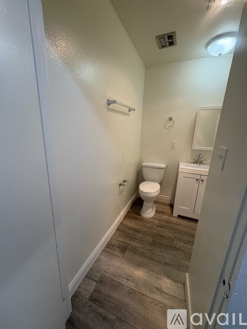A small bathroom with a toilet, sink, and mirror.