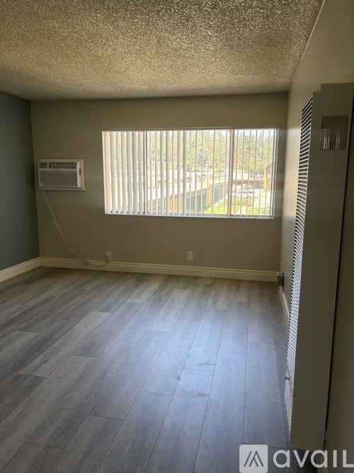 A room with a window and a wall-mounted air conditioner unit.
