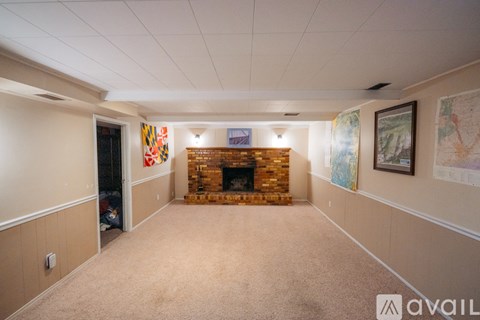 A living room with a fireplace and a painting on the wall.