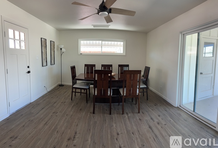 A room with a dining table and chairs.
