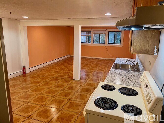 A kitchen with a stove top oven and a tile floor.