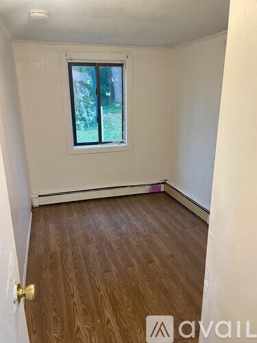 A room with a wooden floor and a window.