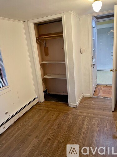 A room with a white door and a wooden floor.