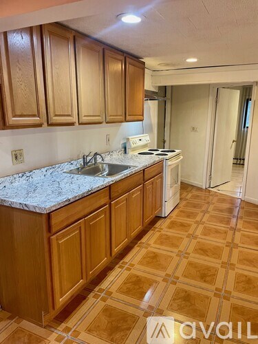 A kitchen with wooden cabinets and a marble countertop.
