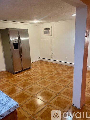 A kitchen with a tile floor and a fridge.