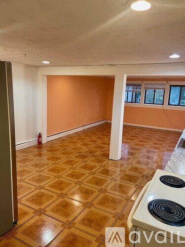 A room with a tiled floor and a fire extinguisher on the wall.
