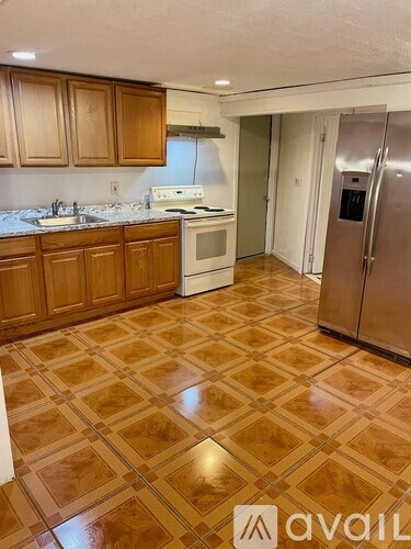 A kitchen with wooden cabinets and a tiled floor.