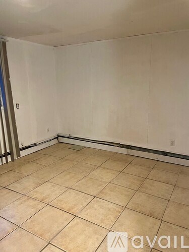 A room with beige tiled flooring and white walls.