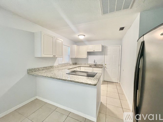 A kitchen with a granite countertop and stainless steel appliances.