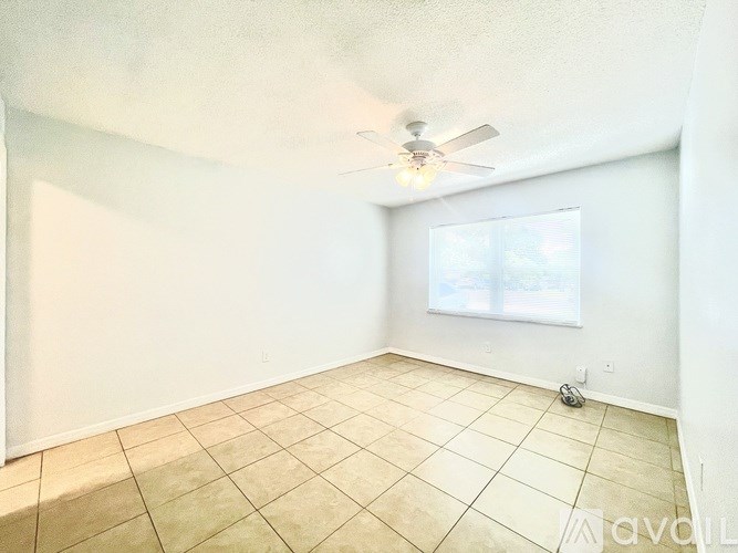 A room with a ceiling fan and a window.