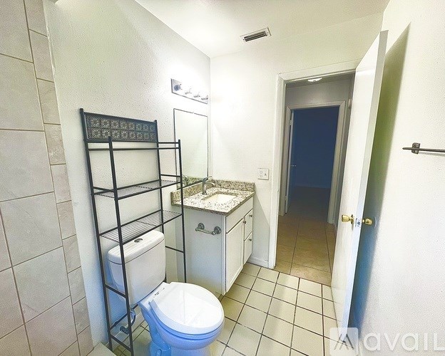 A bathroom with a toilet, sink, and a towel rack.