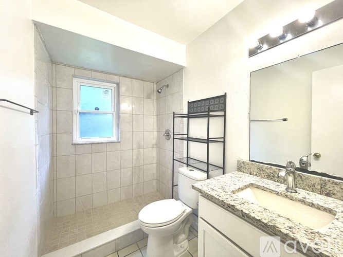 A bathroom with a toilet, sink, and shower.