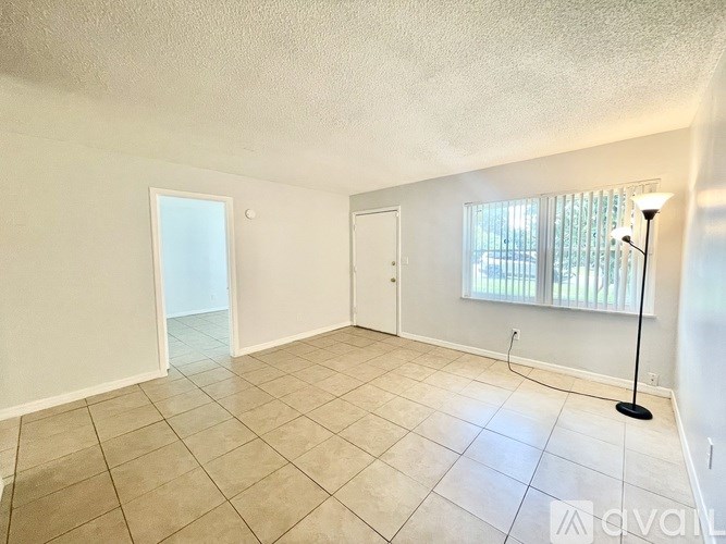 A room with beige tiled flooring and white walls.