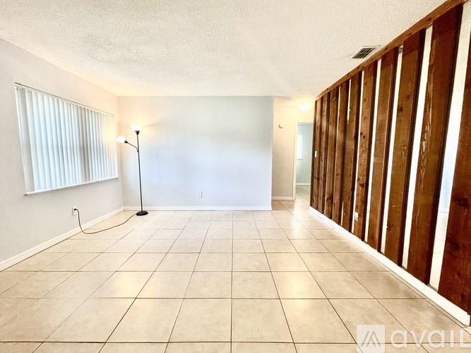 A room with a tiled floor and a lamp on the left side.