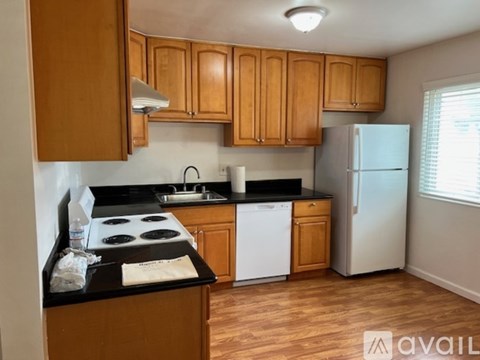 A kitchen with wooden cabinets and black countertops.