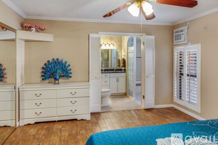 A room with a ceiling fan and a mirror on the wall.