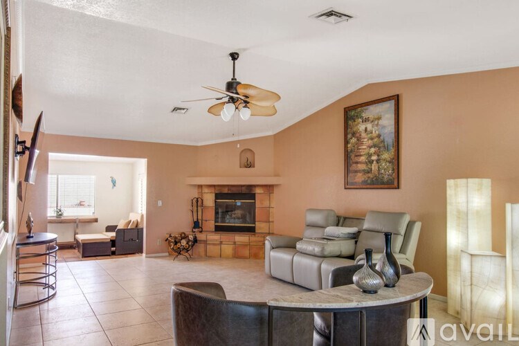 A living room with a fireplace and a painting on the wall.
