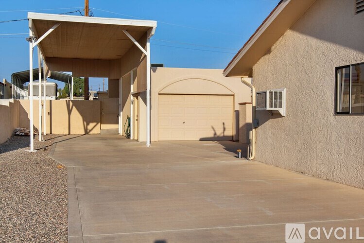 A house with a covered driveway and a garage door.