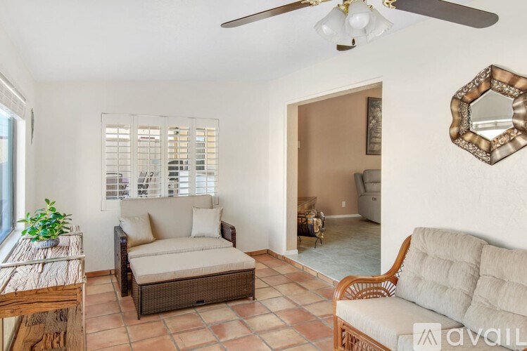 A living room with a couch, chair, and a mirror on the wall.