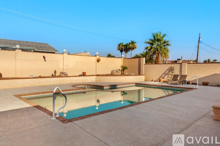 A pool with a glass divider is surrounded by a concrete patio.