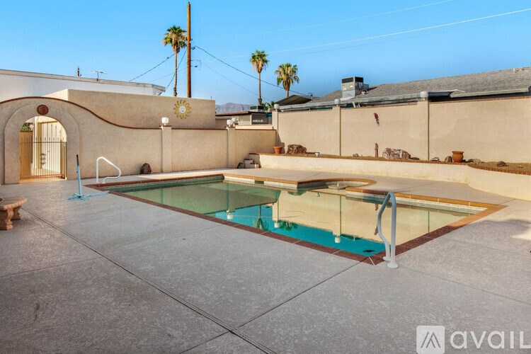 A pool in a backyard with a wall and a door.