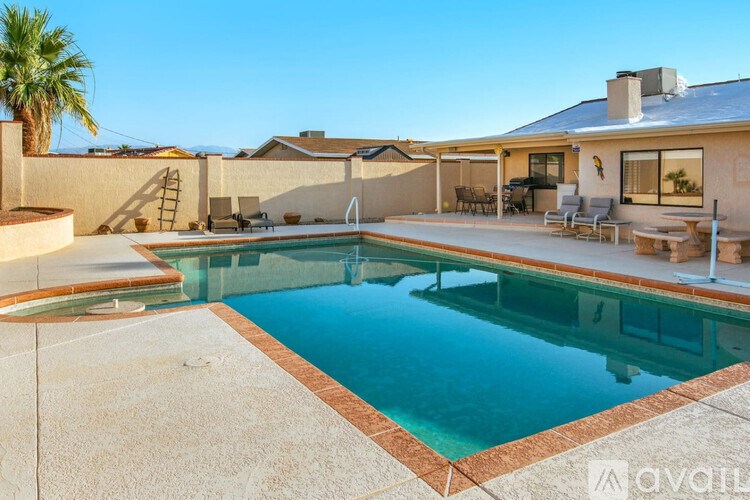 A swimming pool in a backyard with a house in the background.