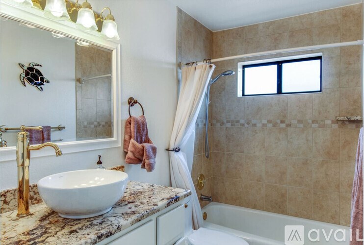 A bathroom with a marble countertop and a large mirror.