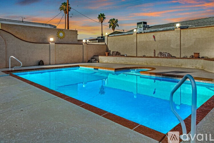 A pool with a brownish water and a brownish poolside.
