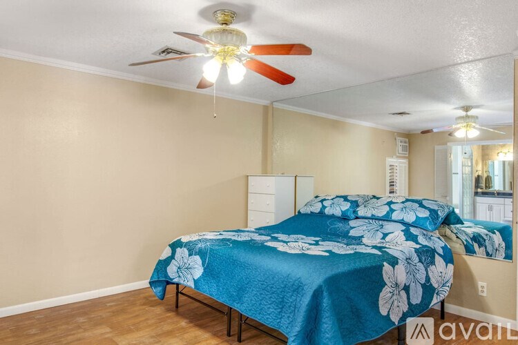 A bedroom with two beds covered in blue bedding with white flowers.