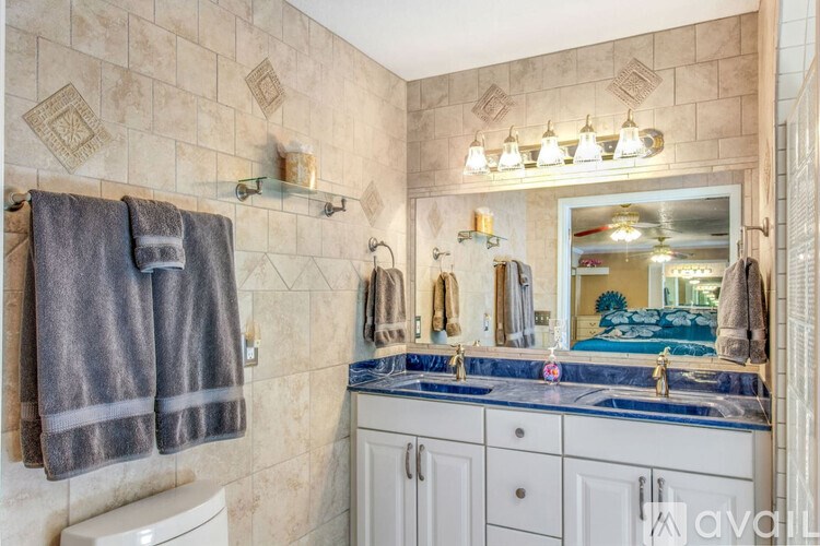 A bathroom with a towel hanging on the wall and a mirror above the sink.