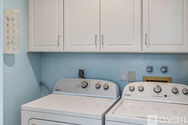 Two white front loading washing machines in a laundry room.