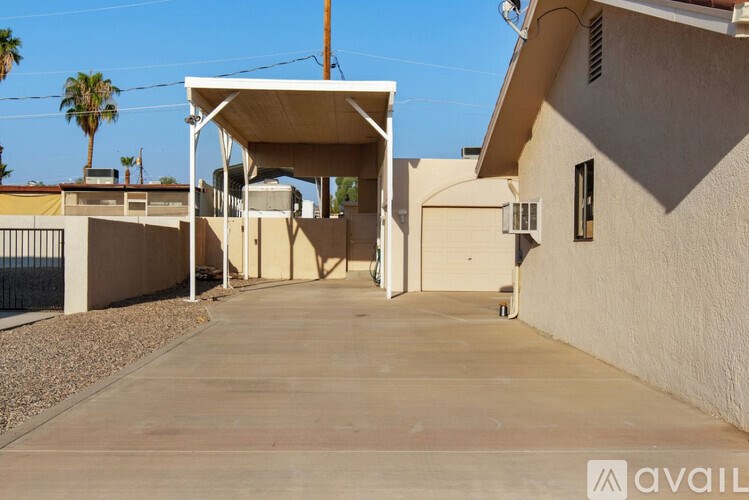 A concrete driveway leads to a house with a covered entrance.