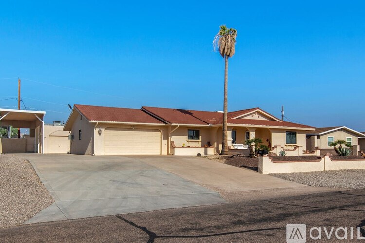 A house with a brown roof and a palm tree in front.