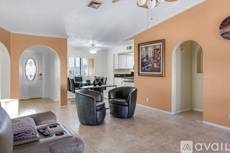 A living room with a grey couch and a black chair.