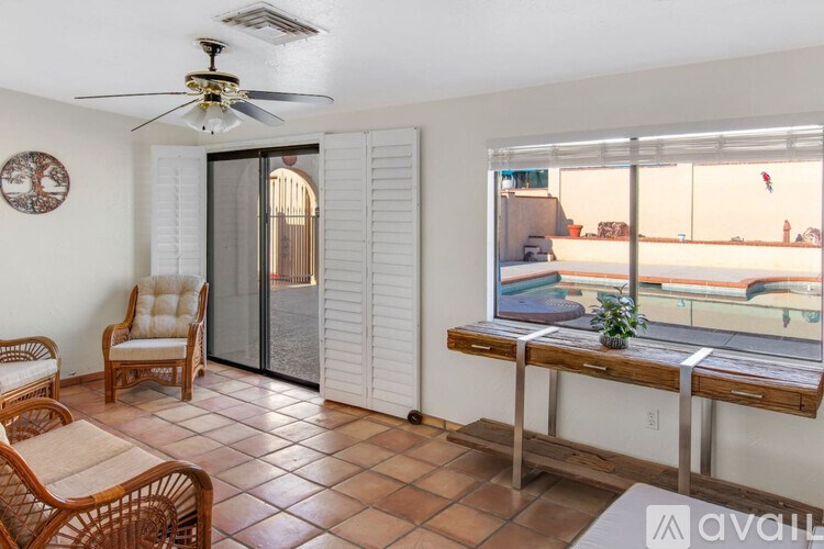 A balcony with a table and chairs overlooks a pool.