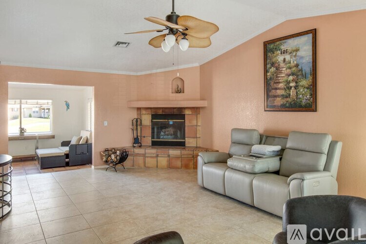 A living room with a fireplace and a painting on the wall.