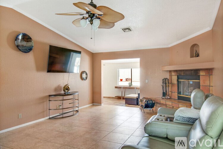 A living room with a green couch and a ceiling fan.