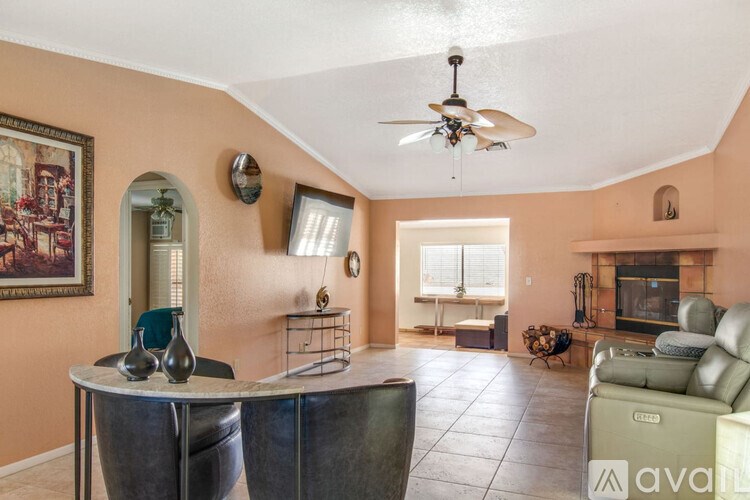 A living room with a round table and a fan.