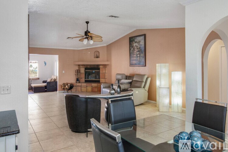 A living room with a black table and chairs.