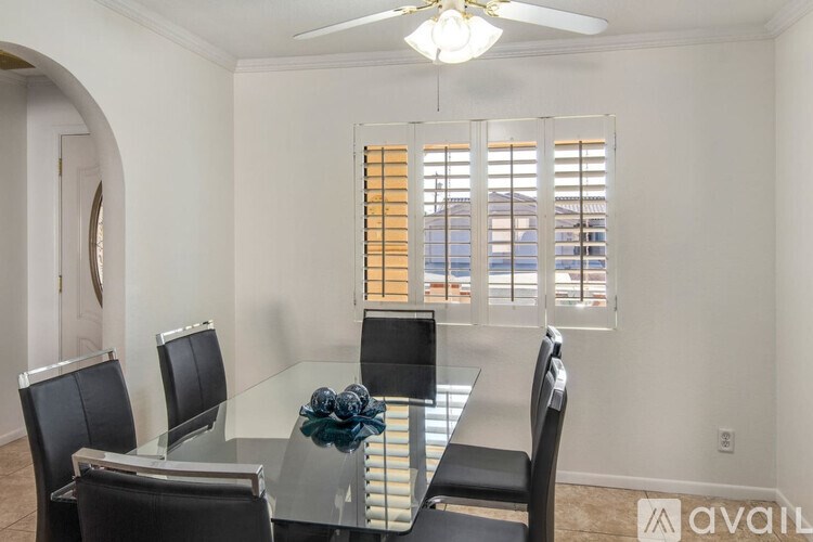 A dining room with a glass table and chairs.