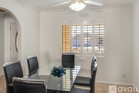 A dining room with a glass table and chairs.