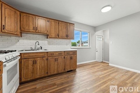 A kitchen with wooden cabinets and a white stove top oven.