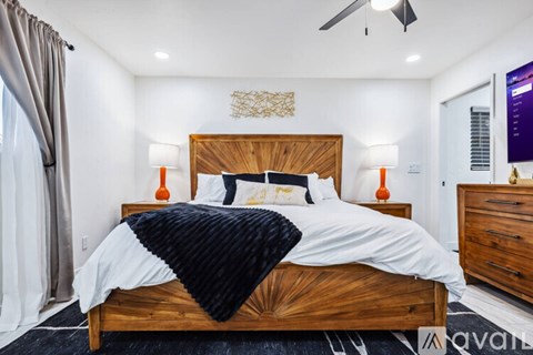 A bedroom with a large bed and a ceiling fan.