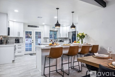 A modern kitchen with a dining table set for four.